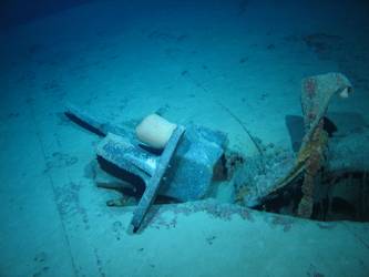 Stbd anchor embedded in steel plate from ship's side in debris field